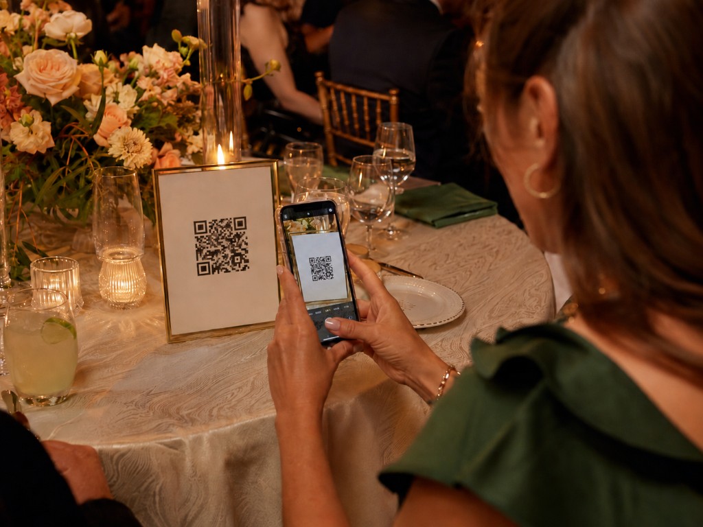 Gast scannt einen QR-Code auf dem Tisch mit dem Smartphone